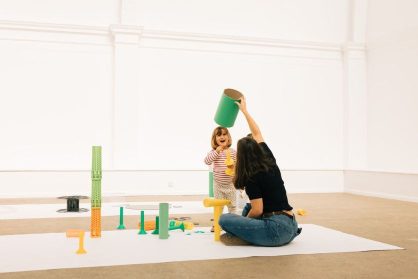 A young person plays with scrap items