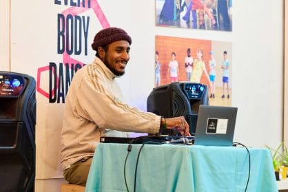 A DJ is smiling behind his desk