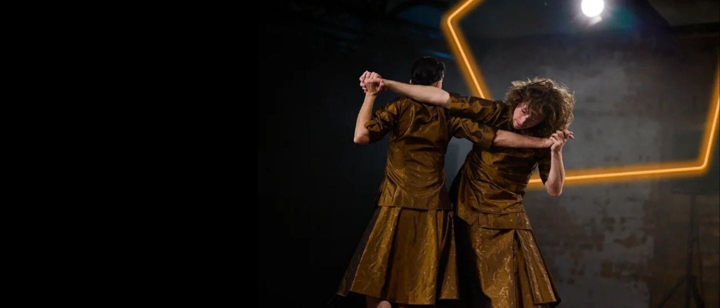 Two people dance arms entwined