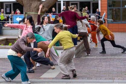 A group of dancers in colourful clothing on the street