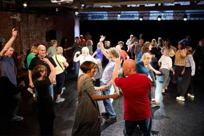 A group of people dance in a studio