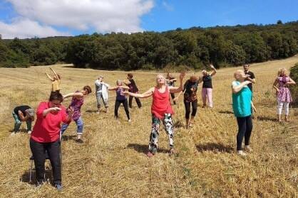 A group of older dancers move in a field