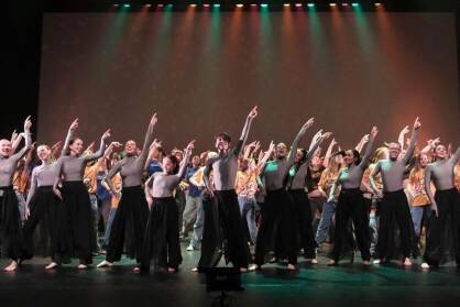 hundreds of dancers disco dancing on stage together