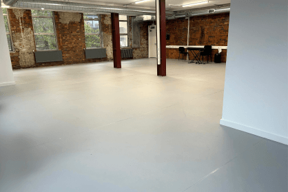 A large empty studio with pale grey dance floor